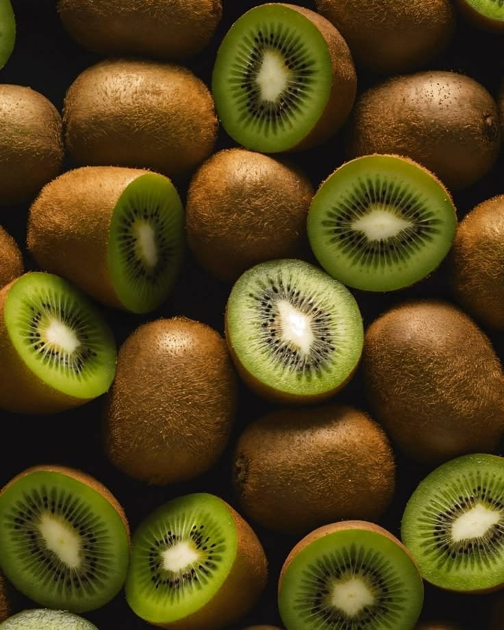 Green kiwi fruit, whole and cut in half, packed closely together